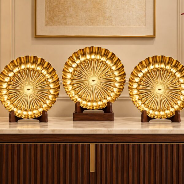 SHREEHOME SWARNA gold PVD footed platters displayed upright on wooden stands on a console table