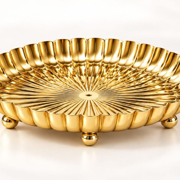 SWARNA gold PVD footed platter viewed from an angle, showing its fluted rim and rounded feet